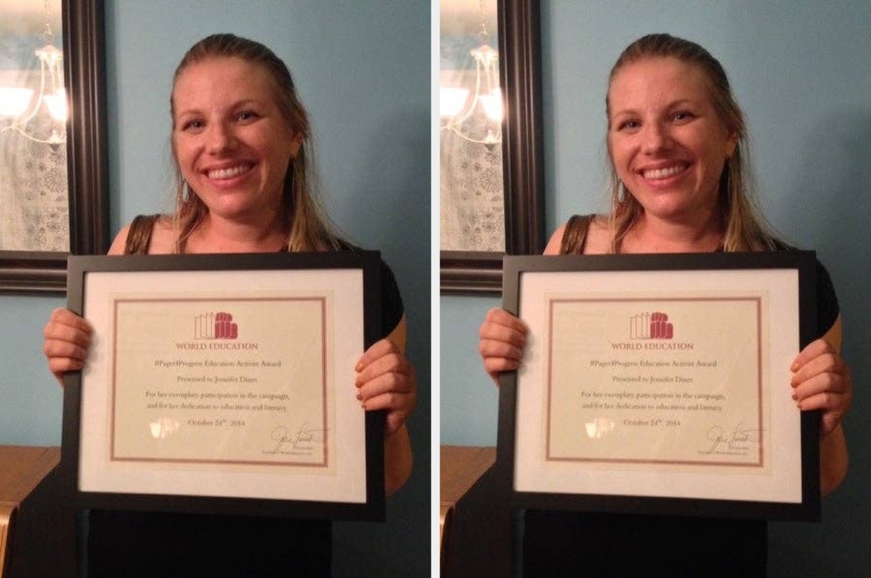Smiling woman holding an award certificate for professional excellence, framed in black, standing indoors