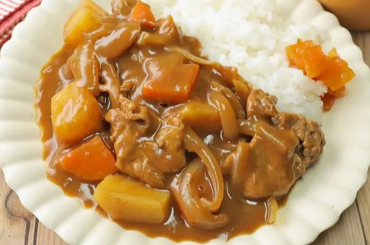 カレーライスの写真。薄切り肉、ジャガイモ、ニンジンが具材として盛り付けられている。
