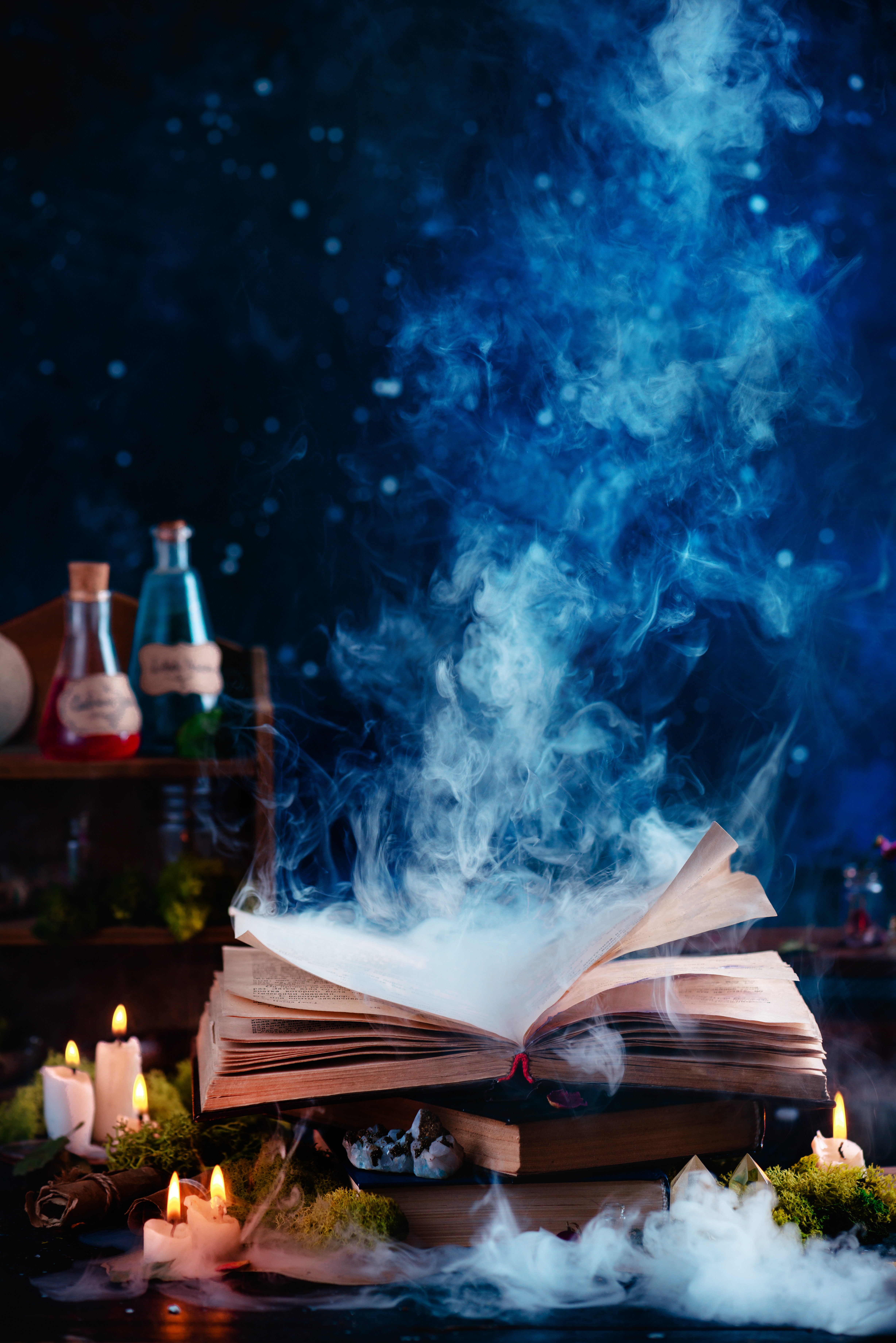 Åpen bok som avgir magisk røyk, omgitt av tente lys og drikkeflasker på en mørk, mystisk bakgrunn