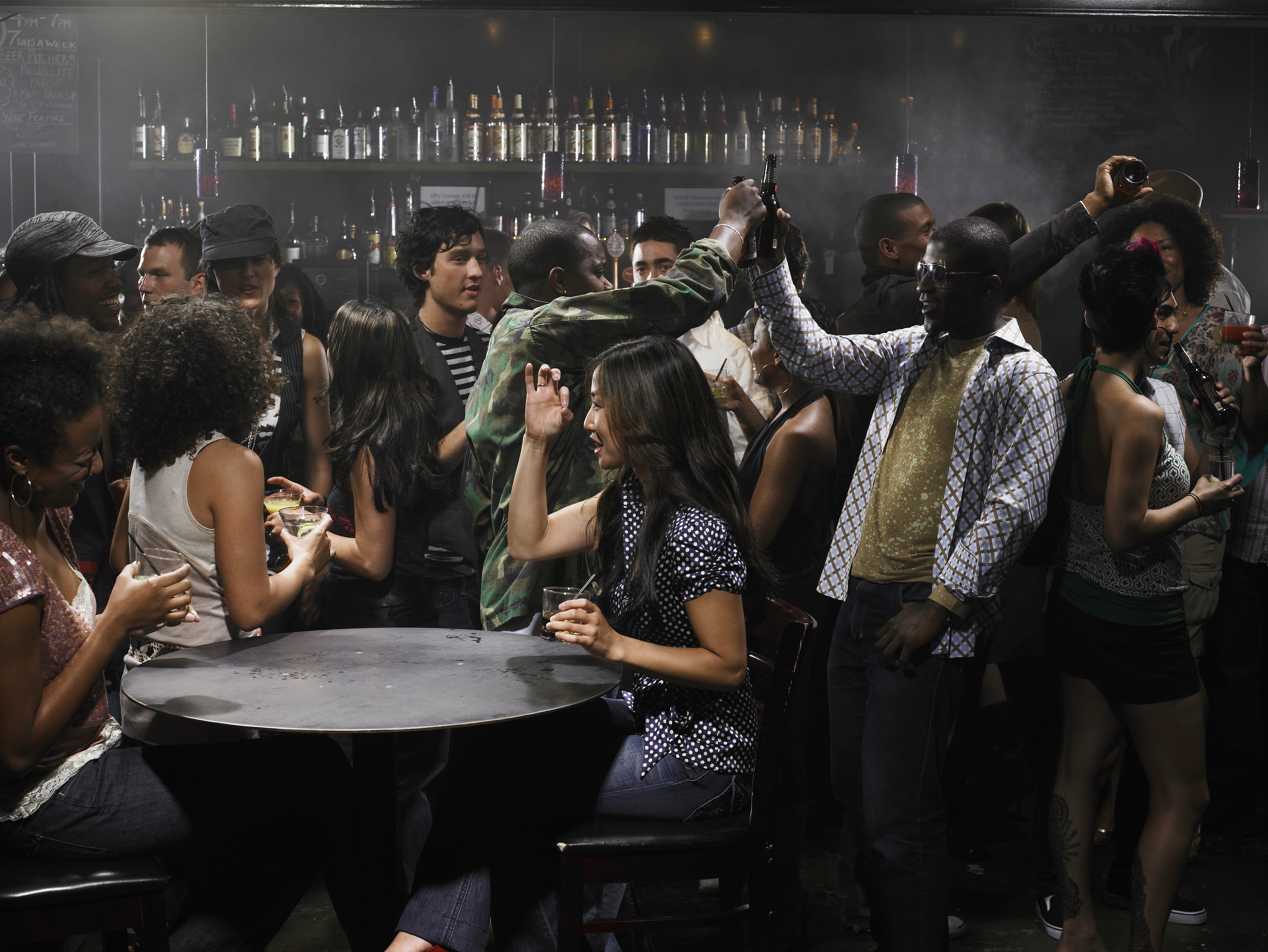 En livlig barscene med forskjellige mennesker som sosialiserer, danser og hever drinker