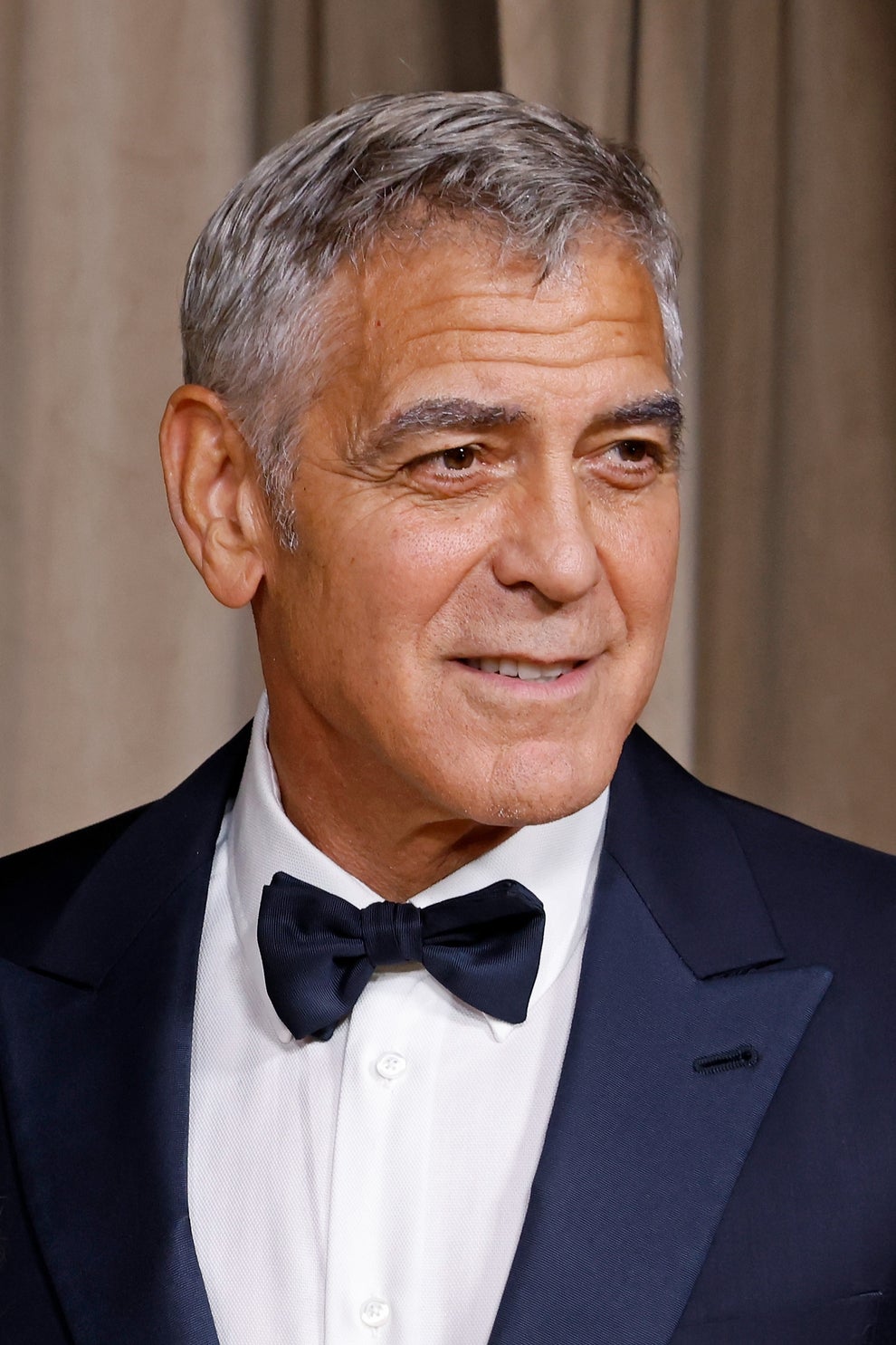 21 Jaw-Dropping "Then And Now" Photos Of Celebrities Who Have Gotten Wayyyyy Sexier With Age 26 Man in a tuxedo with a bow tie at a formal event