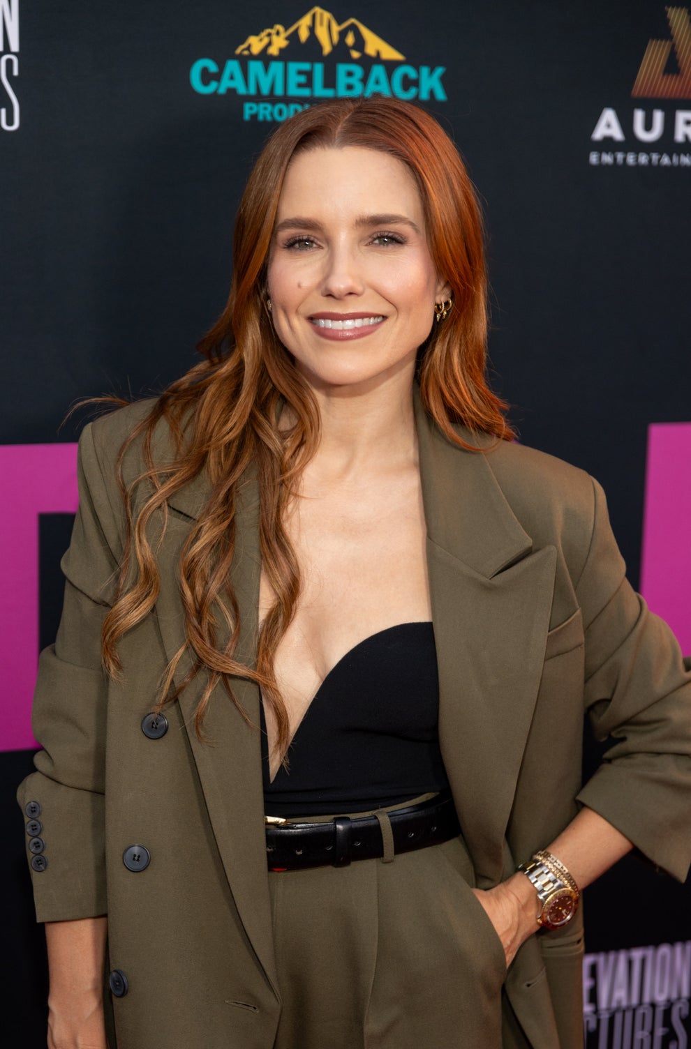 21 Jaw-Dropping "Then And Now" Photos Of Celebrities Who Have Gotten Wayyyyy Sexier With Age 34 Person in a stylish dark blazer and pants on a red carpet, smiling and posing for photos