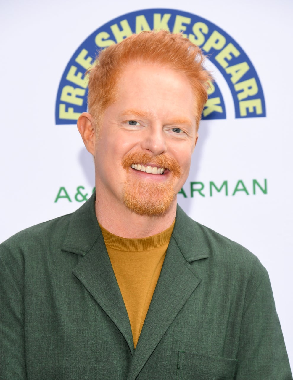 21 Jaw-Dropping "Then And Now" Photos Of Celebrities Who Have Gotten Wayyyyy Sexier With Age 76 Man smiling at an event with a "Free Shakespeare" sign in the background. He is wearing a green blazer over a mustard shirt
