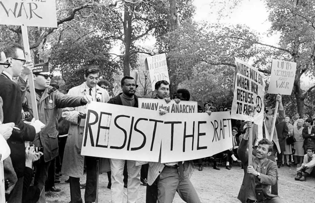 Historical protestation  country   with radical   holding "Resist the Draft" signs during a objection  against the Vietnam War