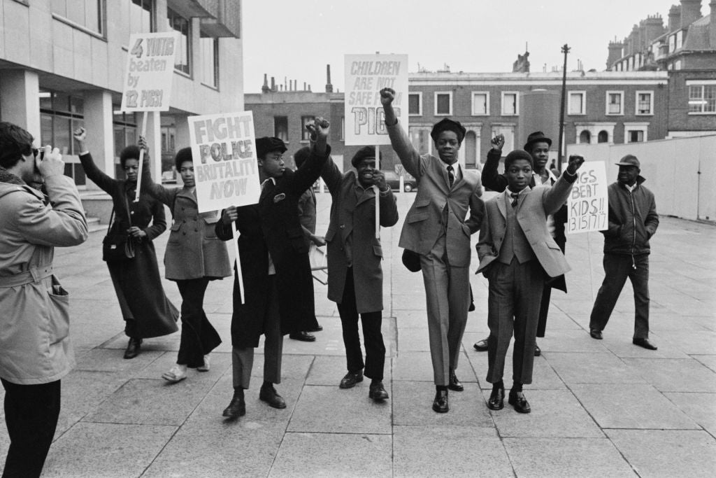 Protesters clasp  signs and rise  fists, advocating for enactment   against constabulary  brutality