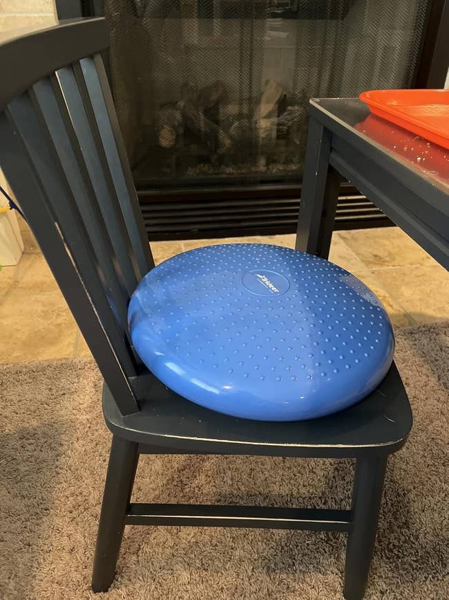 Air-filled equilibrium  cushion connected  a seat  adjacent   a table, enhancing seating comfortableness  and posture