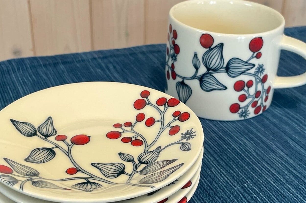 木のテーブルに置かれたARABIA Runo（アラビア ルノ）フロストベリーのカップと小皿のセット。