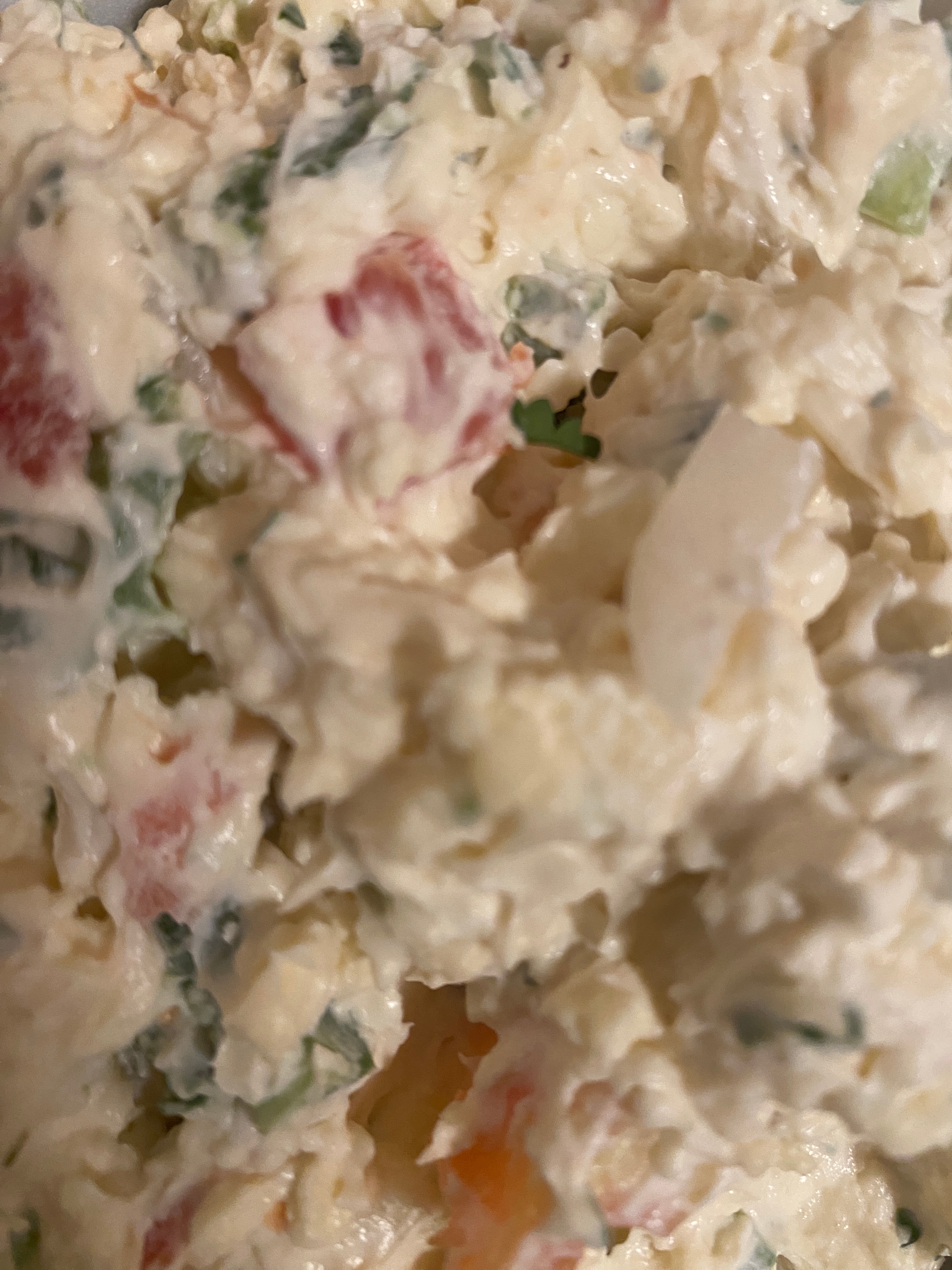 Close-up of a mixed salad with visible chopped vegetables and creamy dressing
