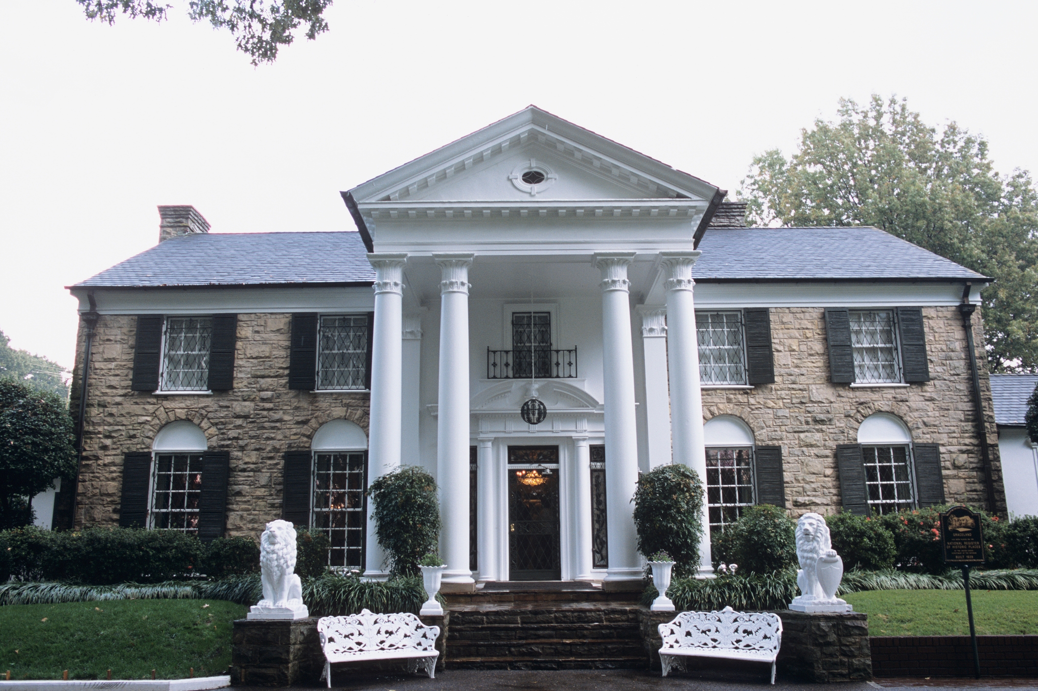 Historic Graceland Mansion with large white columns, stone facade, and lush landscaping