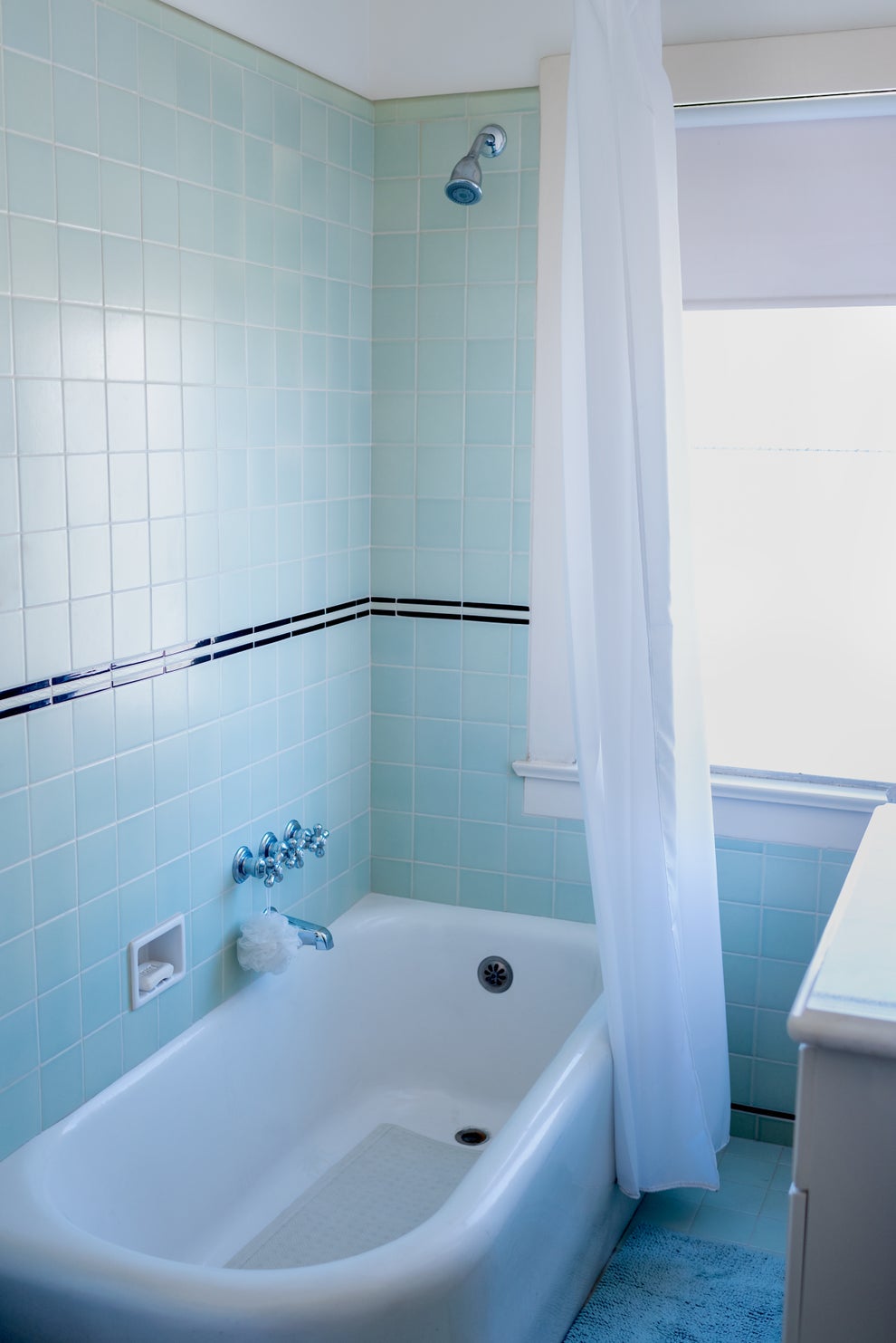 I Actually Think I Lost All Faith In Men After Learning Some Of The Things Women Have Accidentally Found In Men's Homes 6 A simple bathroom with a bathtub, shower, and light tiled walls, featuring a hanging shower curtain and bath fixtures