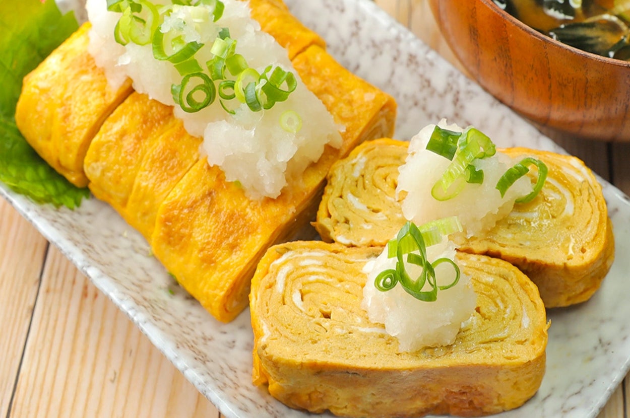 卵焼きが大根おろしとネギを添えて盛られたお皿、隣には味噌汁の入った碗。
