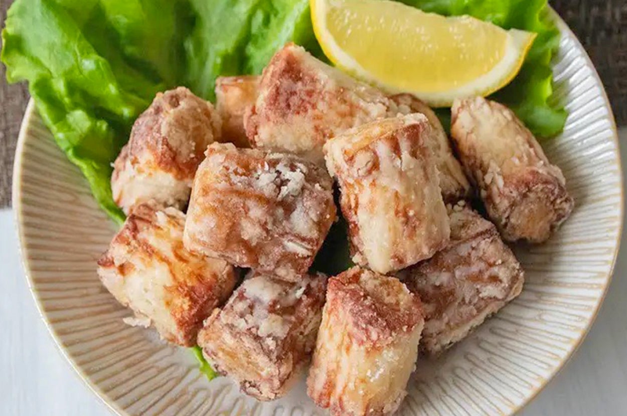 皿に盛られた揚げた魚の一口サイズのキューブとレタス、レモンのスライス。