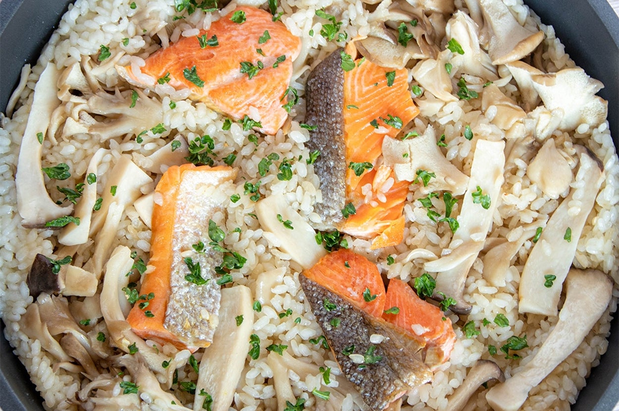 サケときのこのパエリアがフライパンに盛られています。