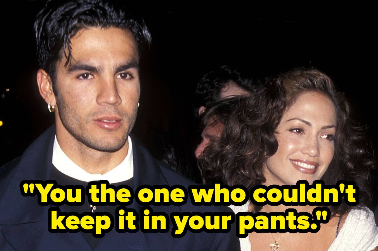 Two people on the red carpet; one wears a formal suit, the other a sleeveless, knee-length dress with a draped shawl, smiling and walking