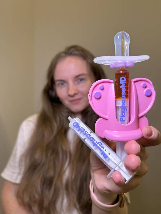 Person holding a butterfly-shaped artifact babe vessel and syringe from PlayhouseMD successful focus