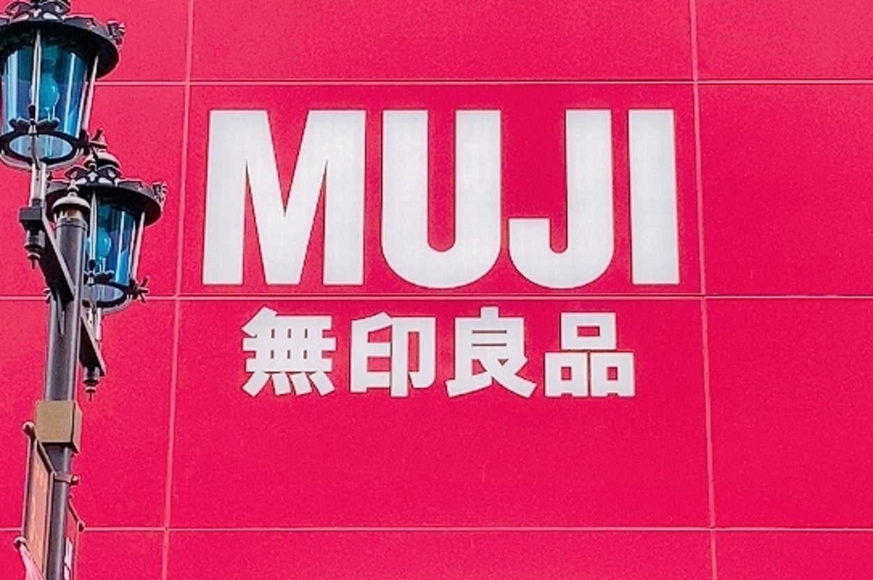 無印良品の店舗入り口。大きなロゴが正面に表示されており、周囲にガラスの外壁が見える。