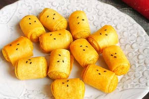 白い皿に盛られた黄色いロール状のお菓子。顔のような模様があり、可愛い印象を与えている。
