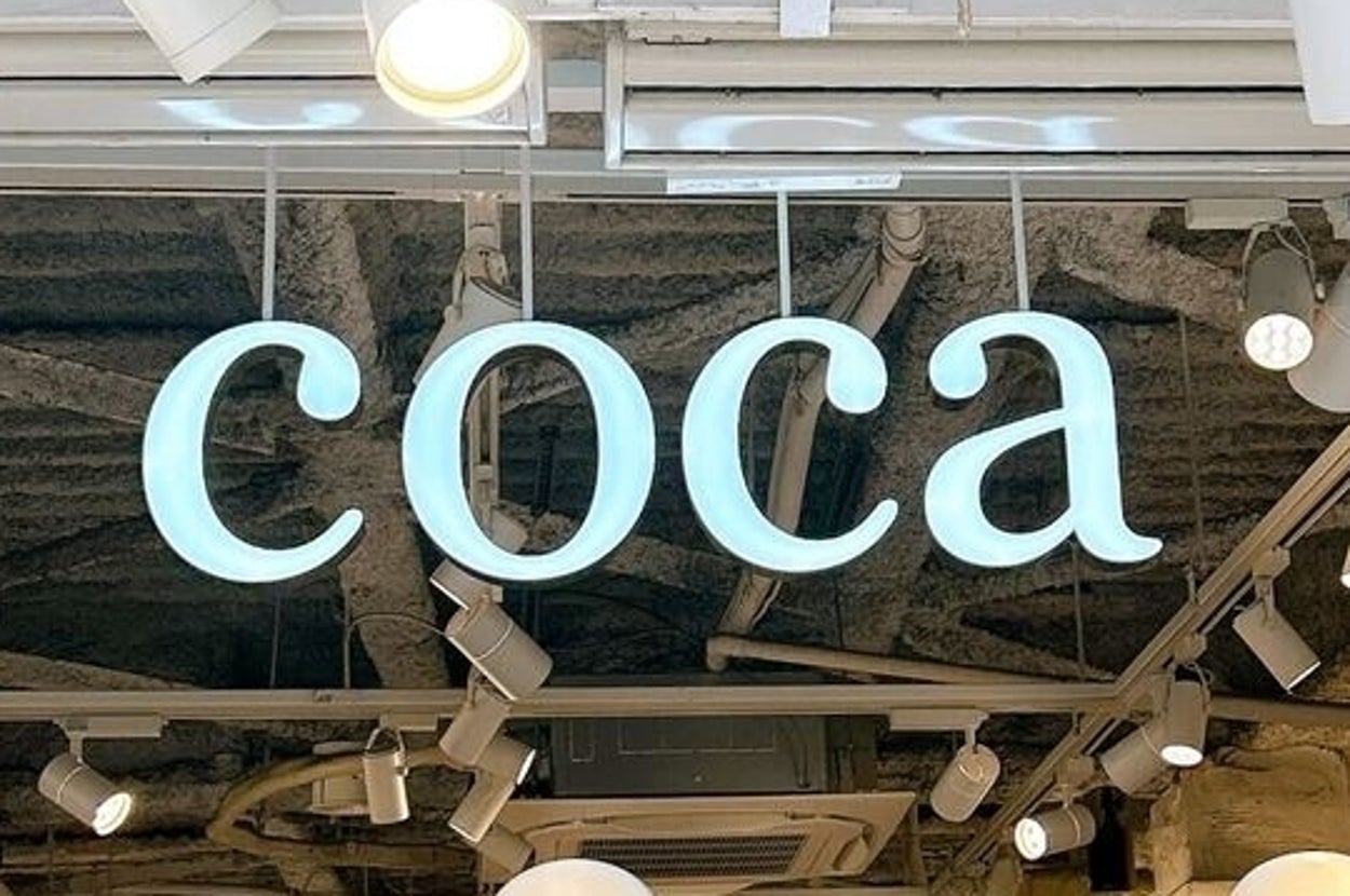 店の入り口に「coca」と書かれた看板があり、店内にはマネキンが並んでいる。