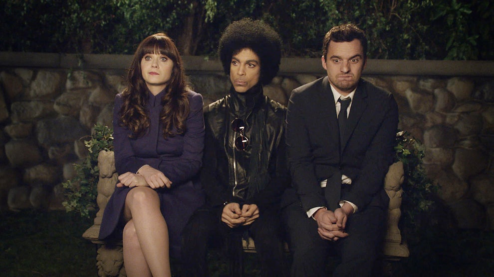 14 Celeb Feuds That Were SO One-Sided, They Were Basically Beefing With A Brick Wall 52 Three people sit on a stone bench; the person in the center wears a leather jacket with a distinct hairstyle, flanked by two others dressed in suits