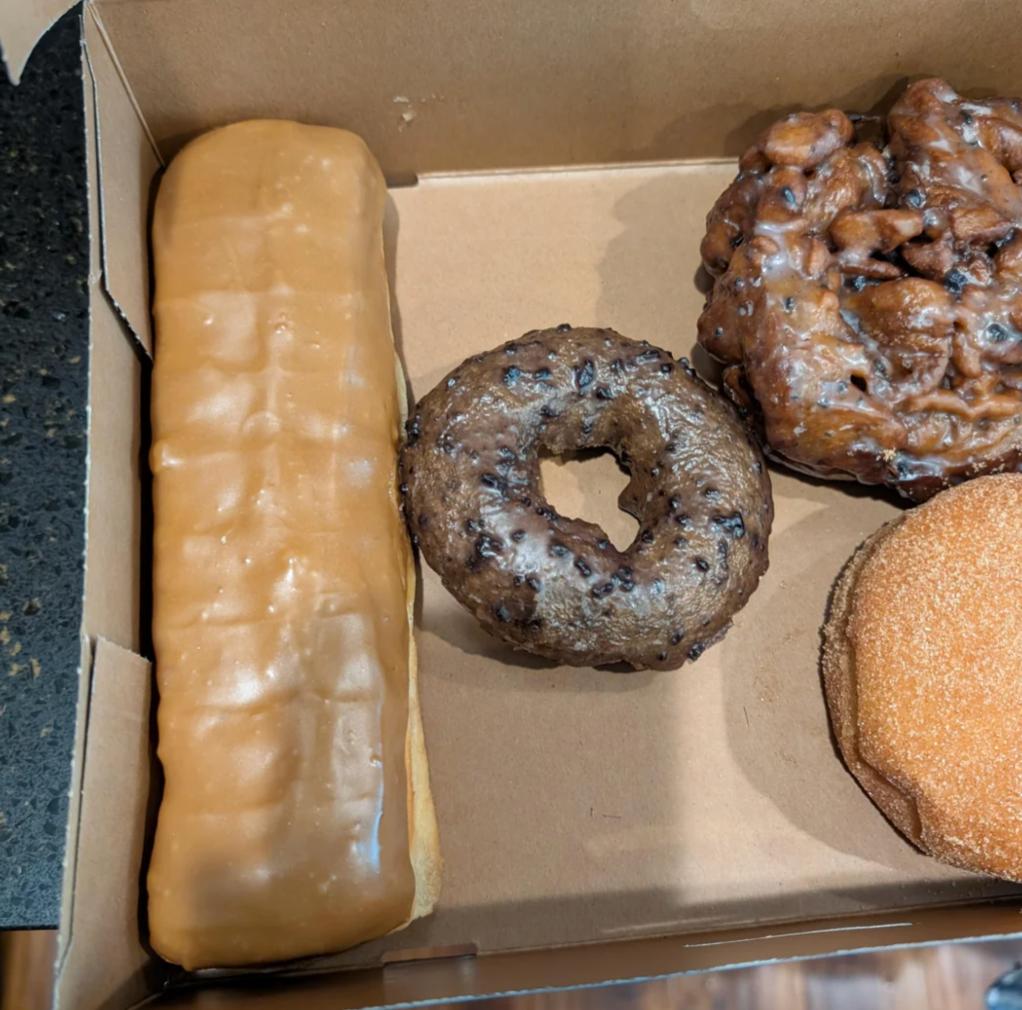 A box of assorted donuts with various shapes and textures, displayed inside a browser with Reddit thread details shown