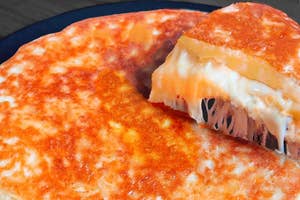 大きなパンケーキ風の料理が切られており、中からチーズと他の具材が見える。