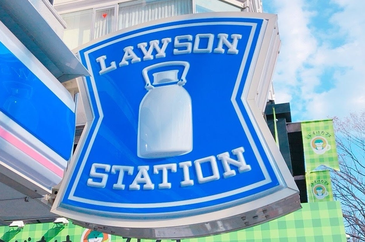 ローソンステーションの看板が都市の背景を背にしています。