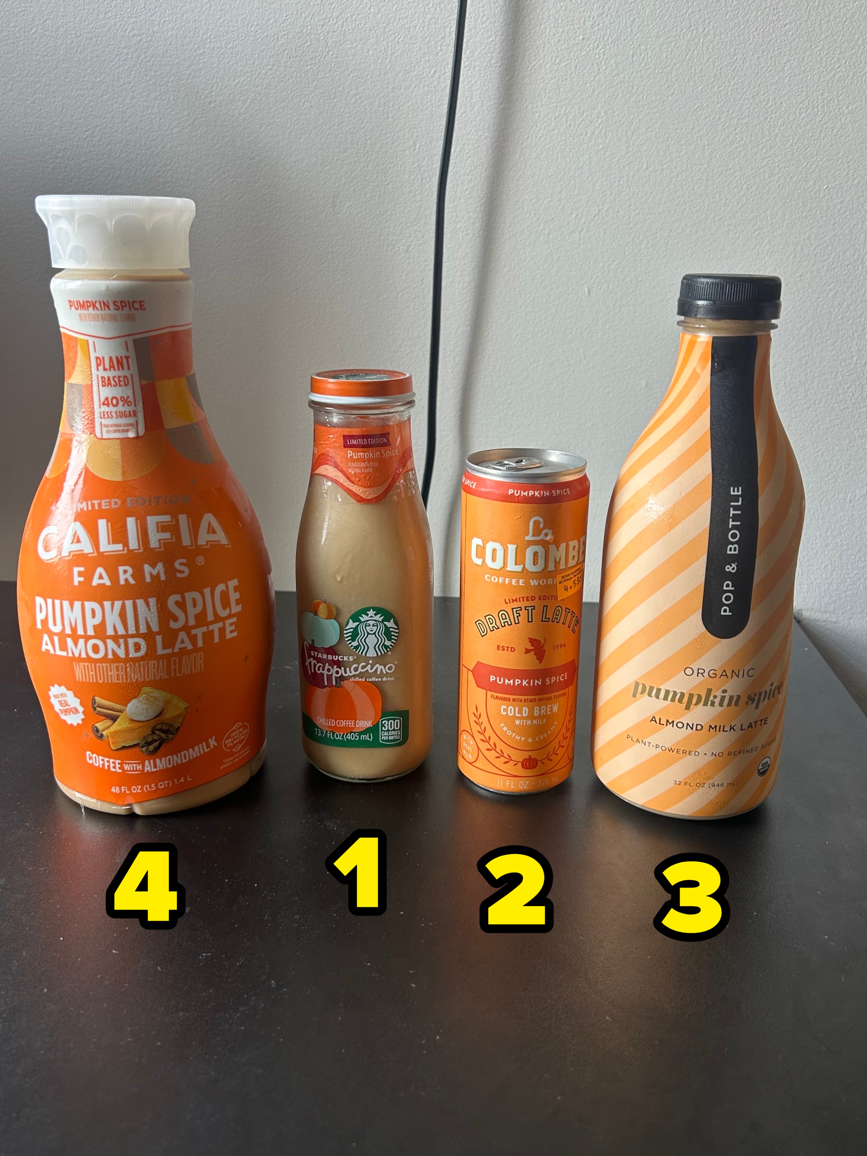 Four pumpkin spice beverages: a Califa Farms almond latte, a Starbucks bottle, a La Colombe draft latte, and a Pop &amp;amp; Bottle almond milk latte