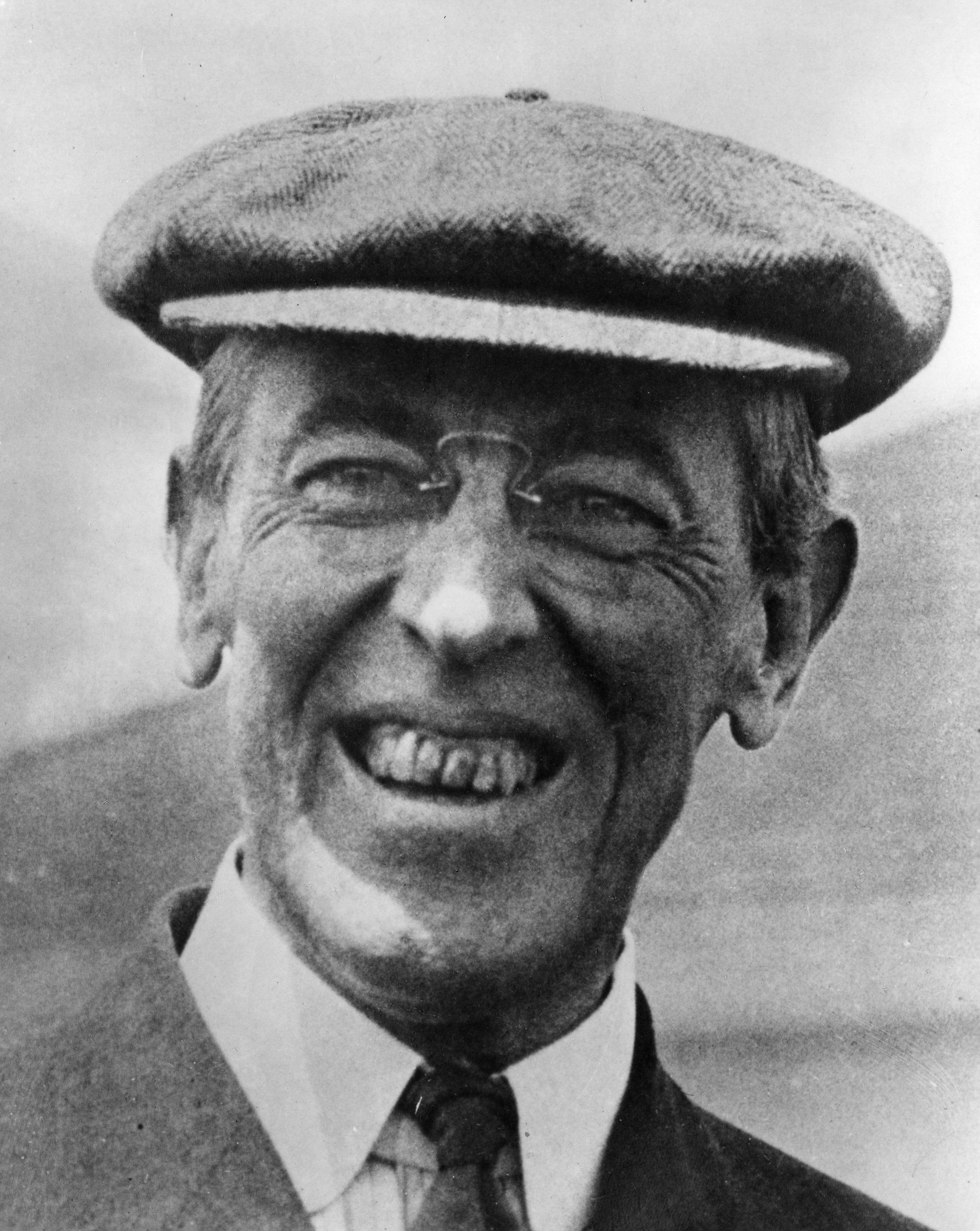 Smiling man wearing a flat cap and glasses