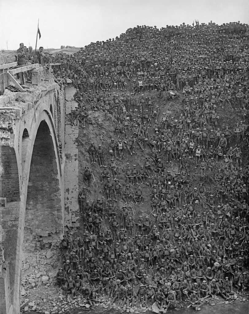 Massive crowd of soldiers densely gathered on a hillside and an adjacent stone bridge, possibly posing or awaiting orders during a historic event