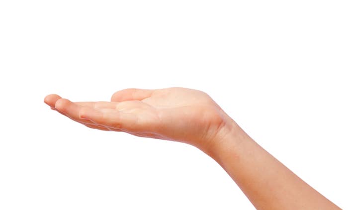 A manus  is extended with the thenar  facing up   against a achromatic  background