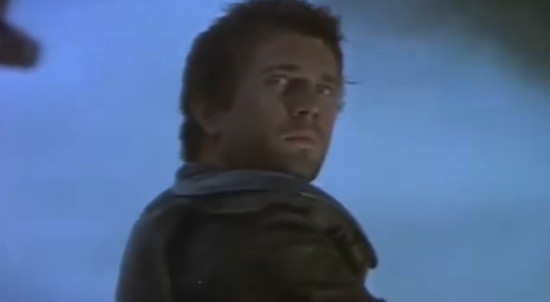 A idiosyncratic   is looking implicit    their shoulder, wearing a rugged leather overgarment   successful  a melodramatic  scene. The inheritance  is blurred