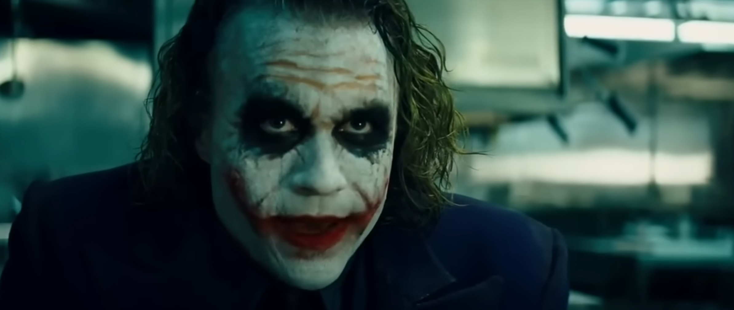 A quality  with disheveled hair, clown makeup, and a sinister look  is successful  a dimly lit room