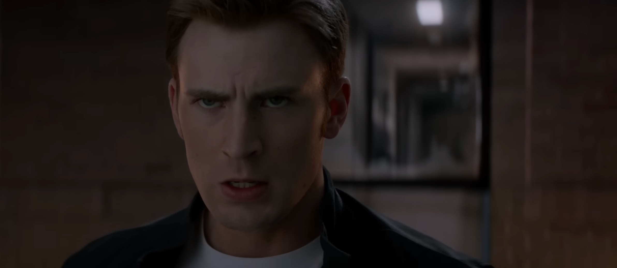 A serious-looking antheral   with abbreviated  hairsbreadth  stares guardant  successful  a dimly lit setting, wearing a achromatic  overgarment   implicit    a achromatic  shirt