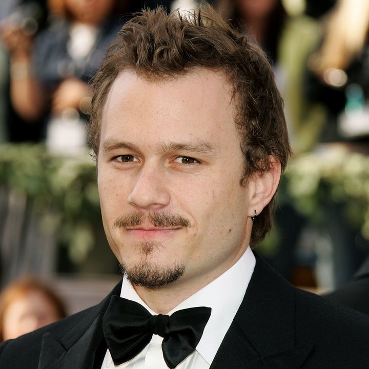 Person in a tuxedo with a bow tie and lapel pin, attending a formal event