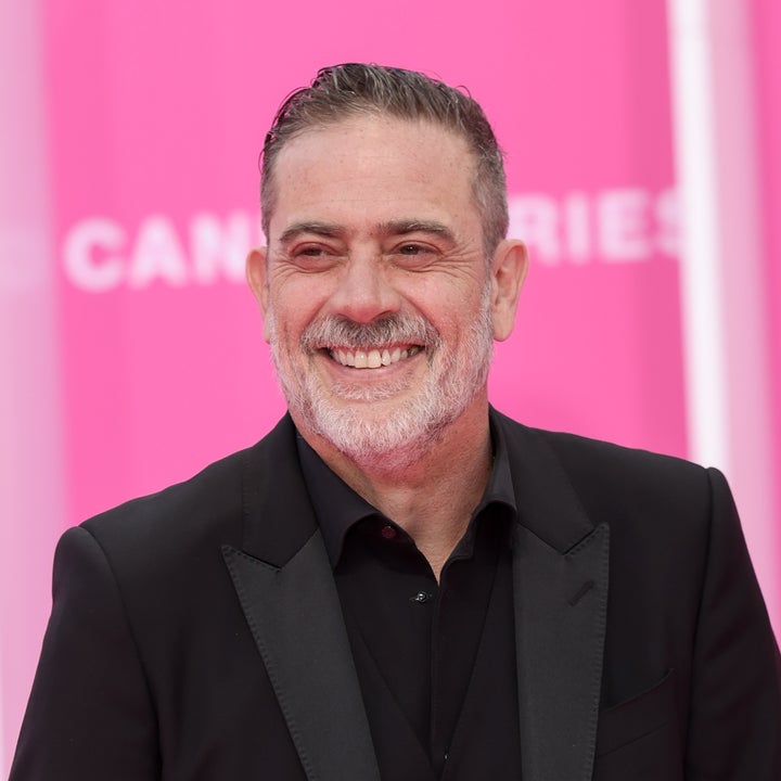 Person in a tailored black suit smiling at a Cannes event