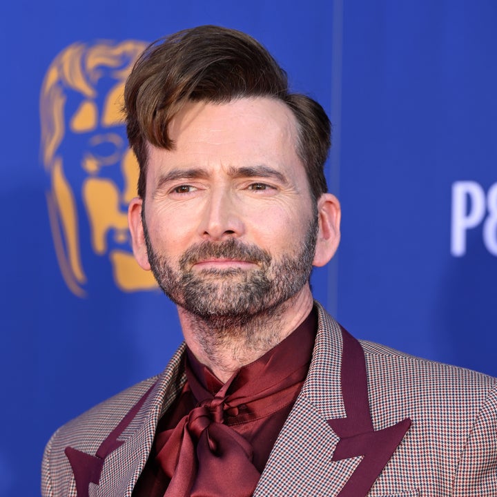 Man in checkered suit with a silk tie poses at an event
