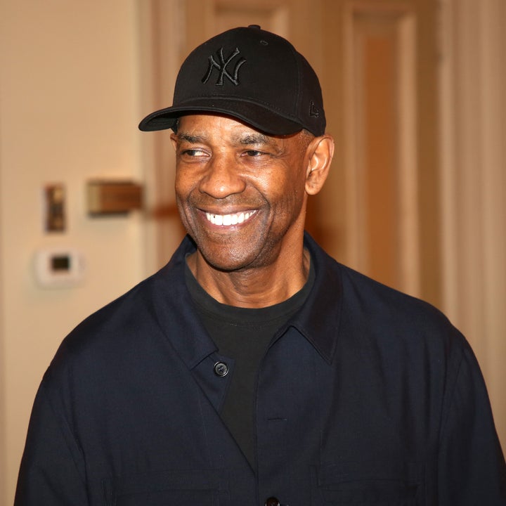 A smiling person in a casual jacket and cap indoors
