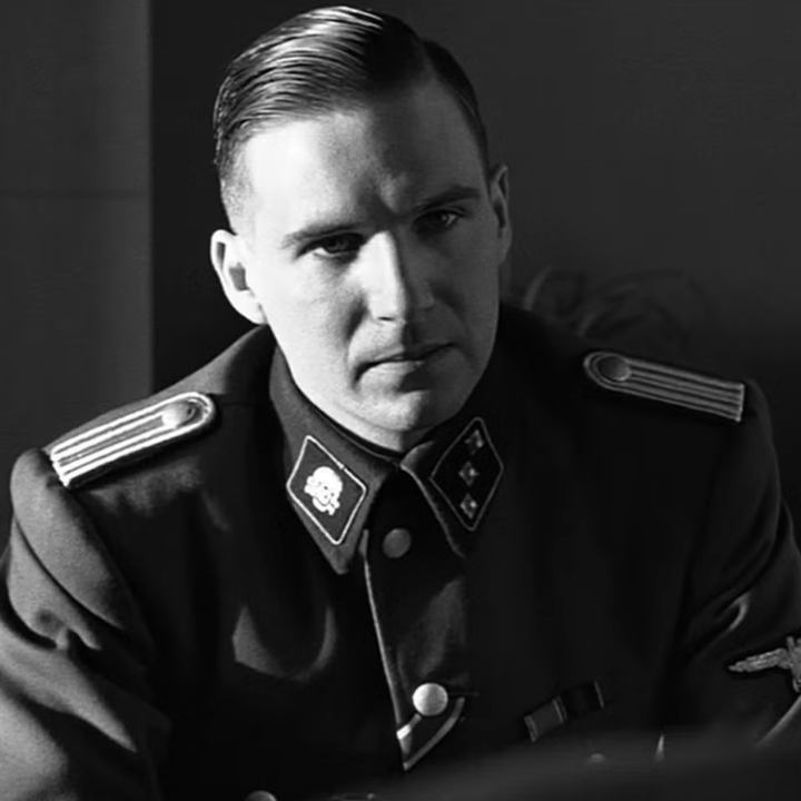 Two people having a serious conversation, one in military uniform with insignias visible, in a formal, indoor setting