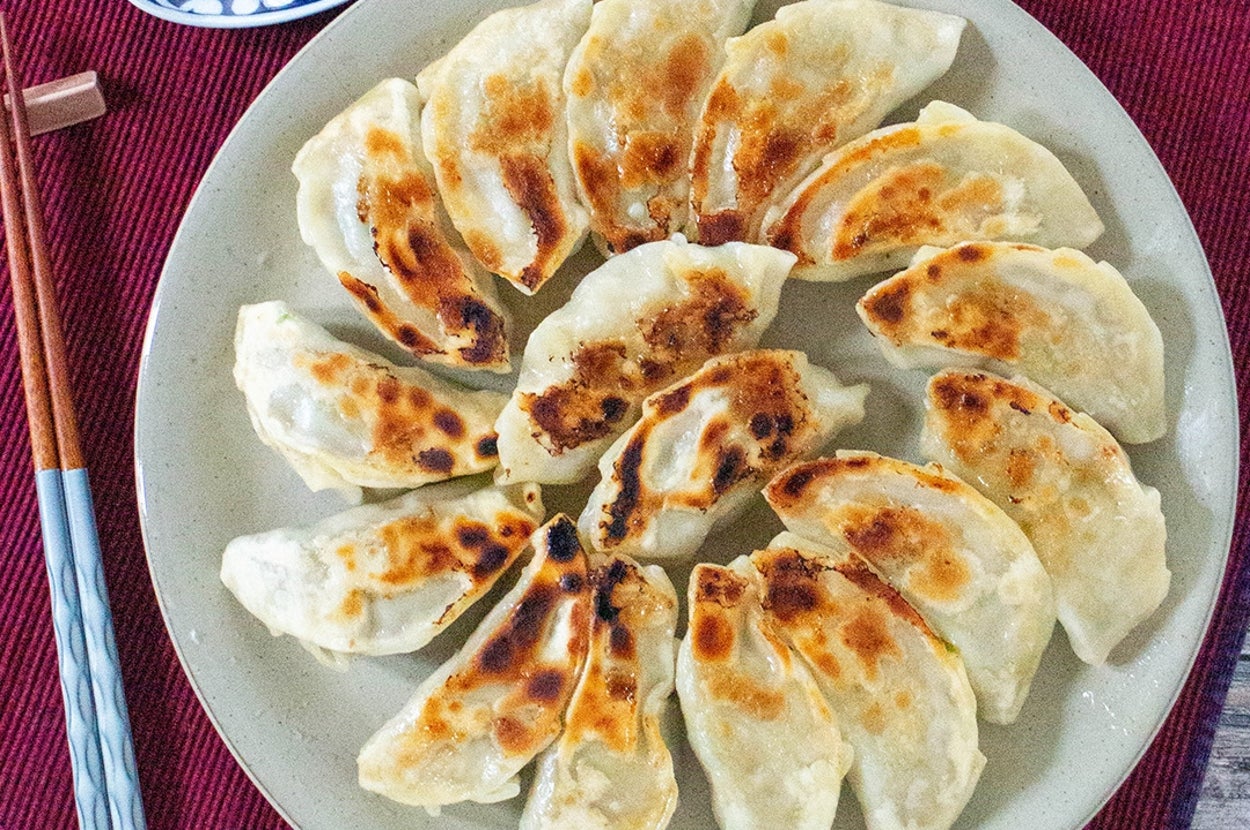皿に並べられた焼き餃子。脇には醤油の入った小皿と箸が置かれている。