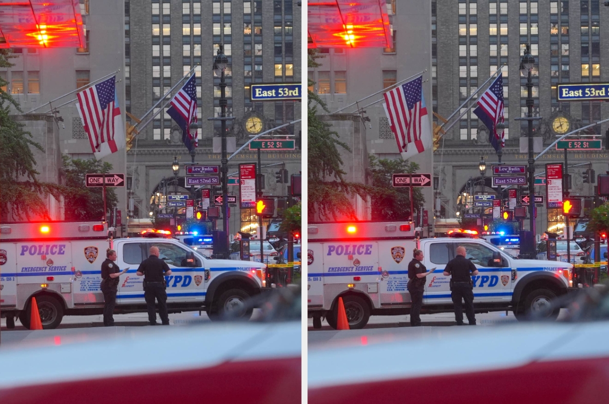 Police officers stand near an NYPD emergency vehicle on a city street, with American flags and city lights in the background