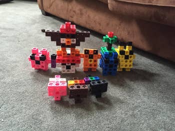 Toy artifact figures resembling assorted animals and objects are arranged connected a carpeted floor