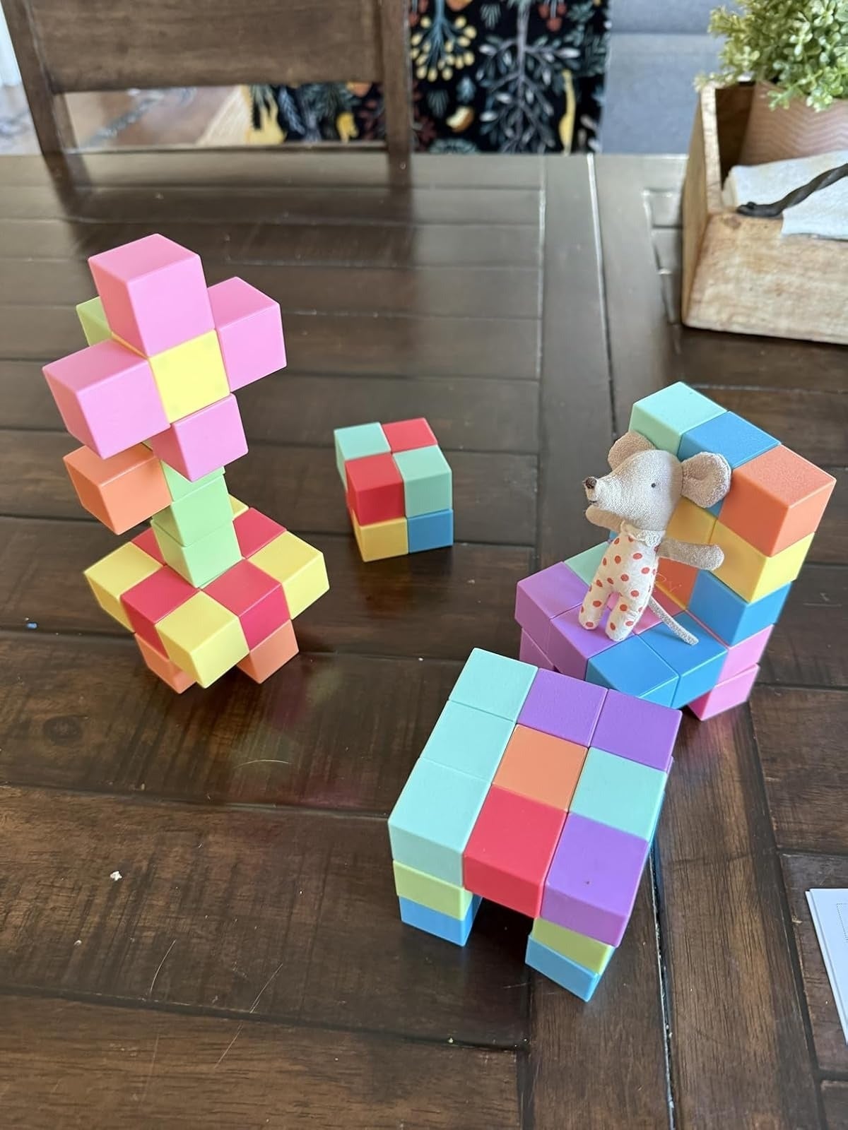 Toy blocks arranged into colorful seat  and operation   connected  table; tiny  cloth  rodent  artifact  sits connected  chair