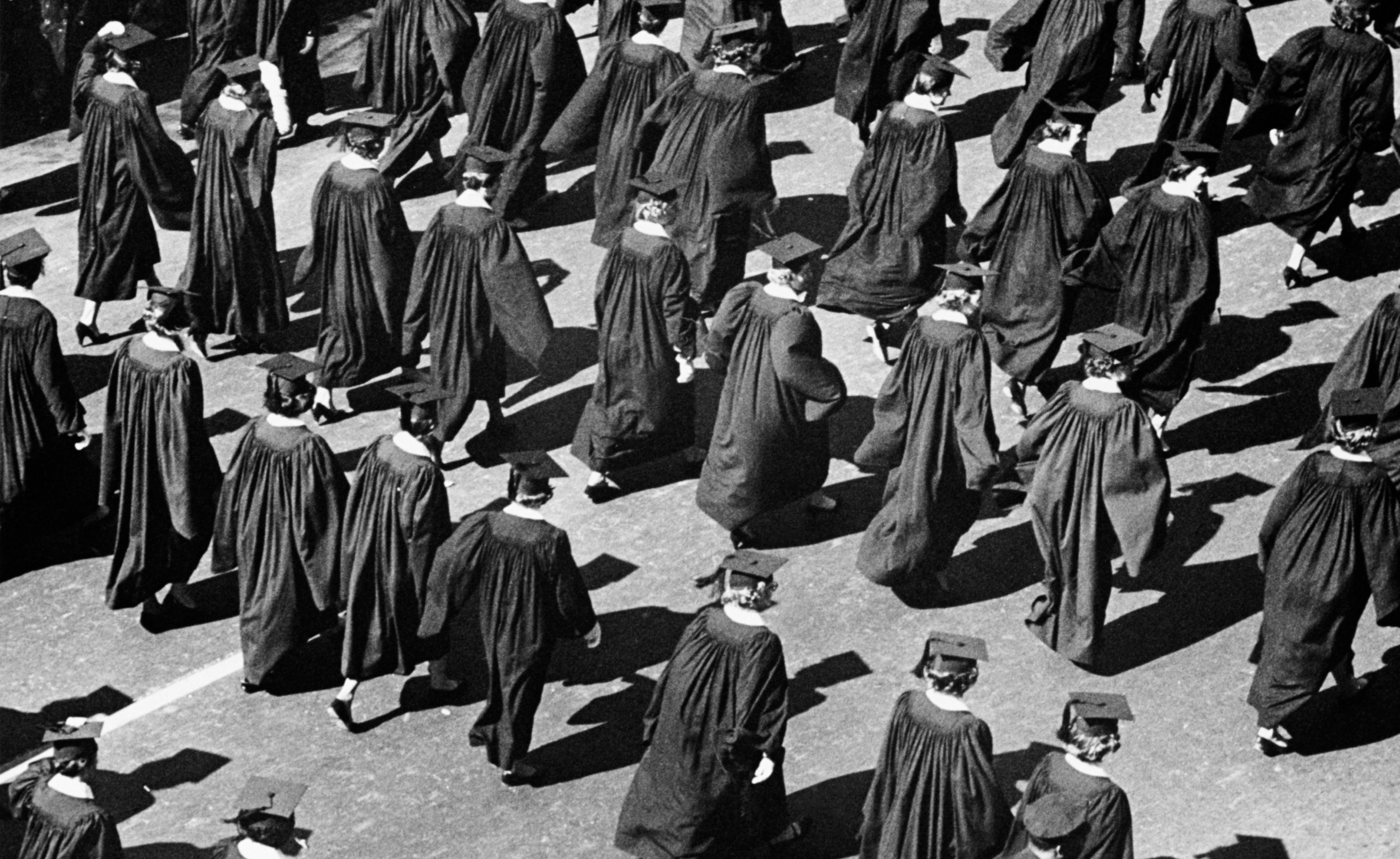 Graduates walking successful  procession wearing caps and gowns during a graduation ceremony