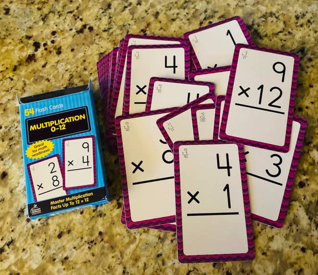 A acceptable   of multiplication flash cards, 0-12, is dispersed  retired  connected  a aboveground  beside the box