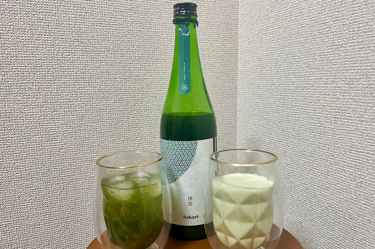 酒と2つのグラスが置かれたテーブル。1つはアイス入り緑色の飲み物、もう1つは白い飲み物。