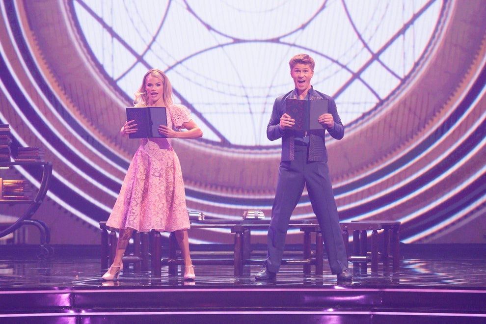 Here's A Show And Movie You Need To Watch This Weekend, Plus More TV And Movie News You Might've Missed 23 Two performers on stage hold script books, with an intricate geometric backdrop. The woman wears a floral dress, and the man wears a dark suit