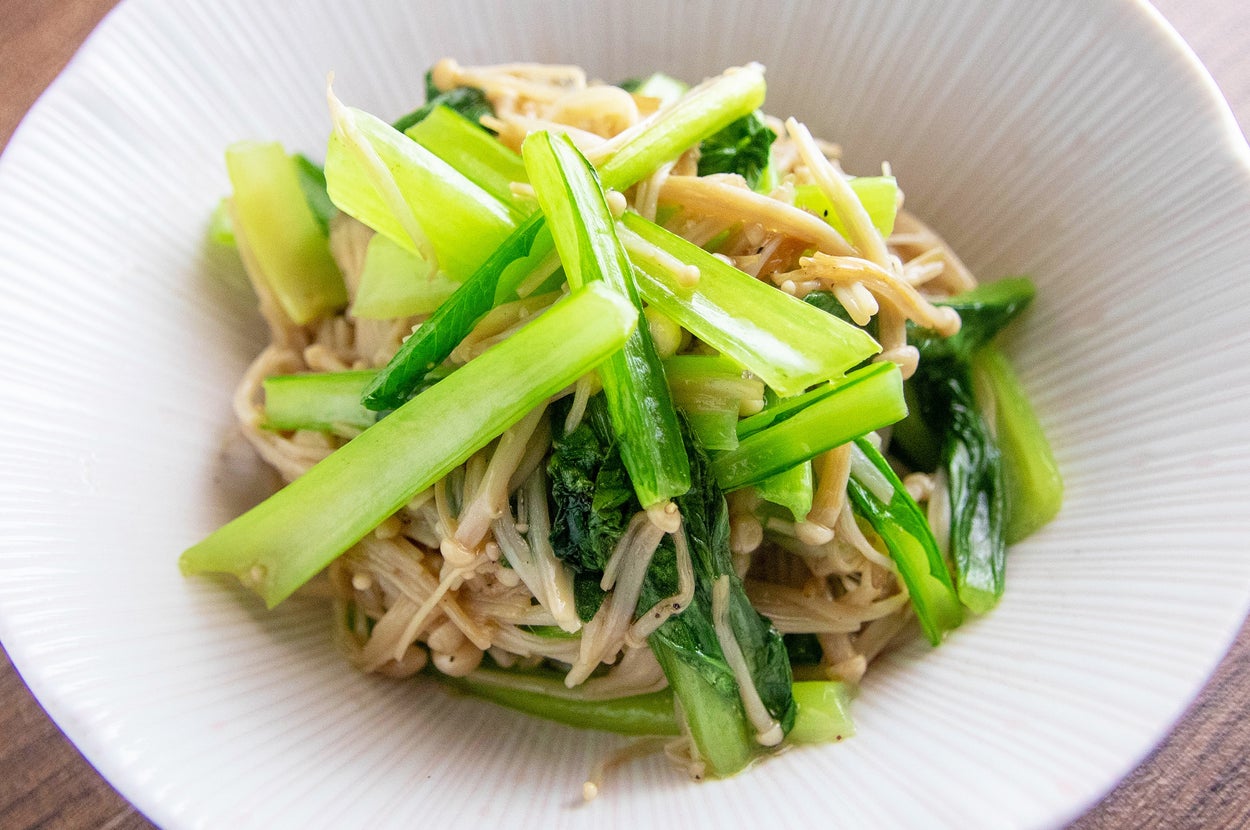 お皿に盛られた中華風の青菜ときのこの炒め物。器は白く、料理が美味しそうに盛り付けられている。