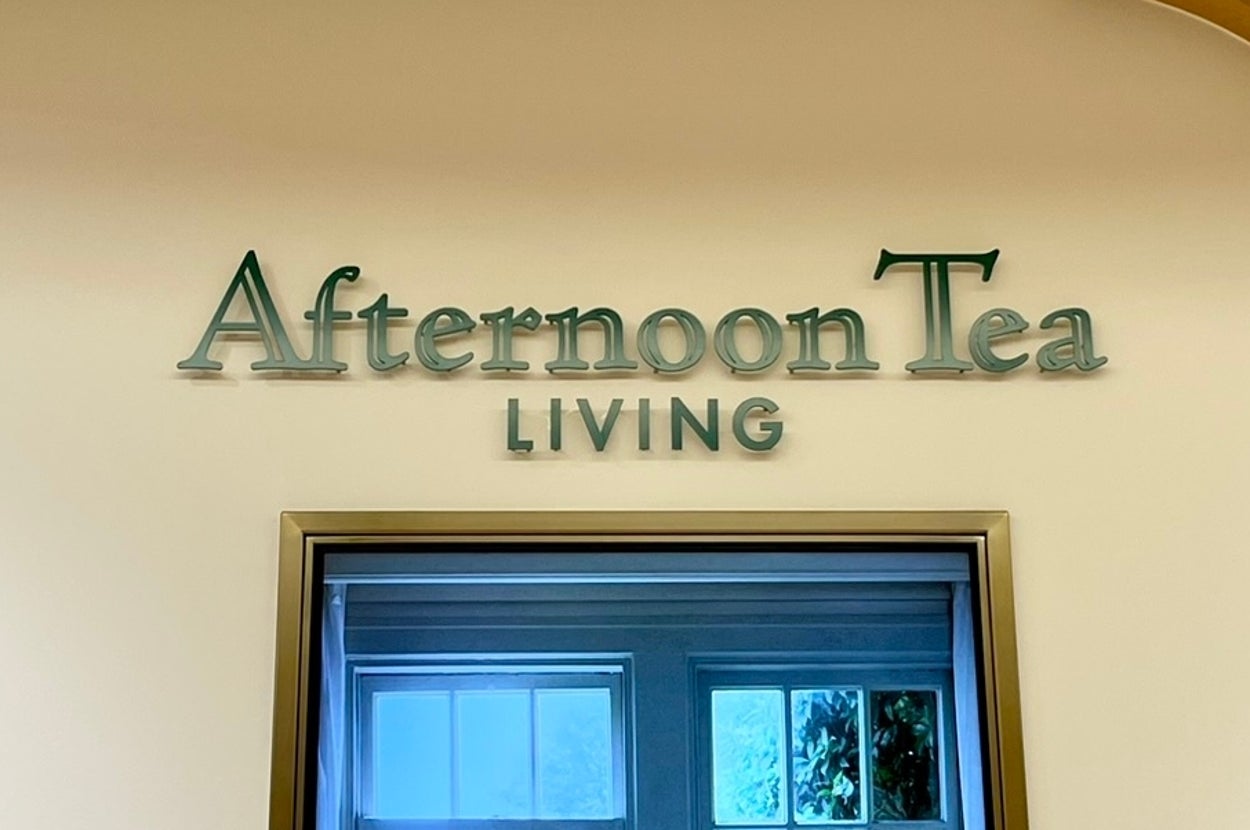 店内のディスプレイウィンドウに飾られた、窓際のテーブルセッティング写真。「Afternoon Tea LIVING」と表示。