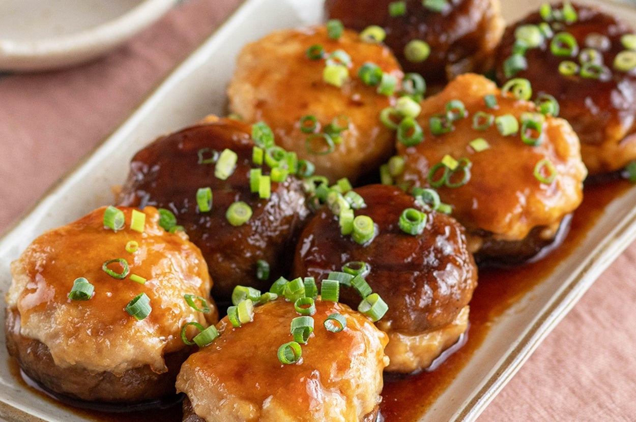 皿に盛られた肉詰めしいたけの料理。ソースがかかり、上には刻みネギが散らされています。