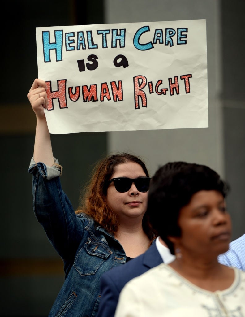 Person holding a motion   that reads, "Health Care is simply a Human Right," astatine  a nationalist   rally